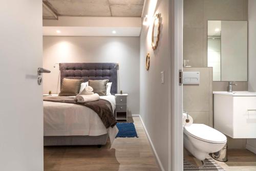 a bedroom with a bed and a bathroom with a toilet at C502 Woodstock Quarter in Cape Town