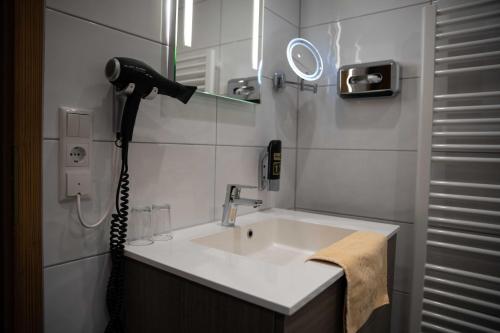 a bathroom with a sink and a hair dryer at Landgasthof Goldener Pflug in Frasdorf