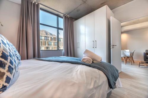 a bedroom with a large bed with a large window at C502 Woodstock Quarter in Cape Town