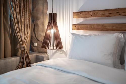 a bedroom with a white bed and a lamp at Bohemian Luxury Boutique Hotel, Adults Only in Naousa