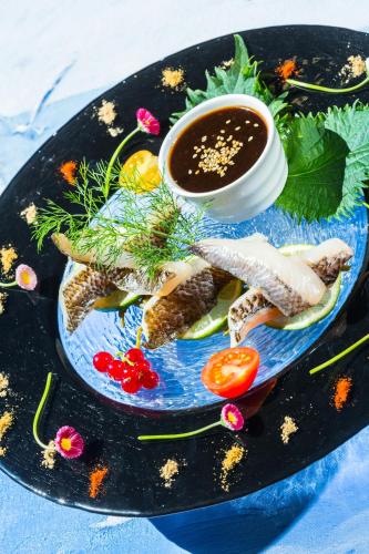 a plate of food with meat and a dipping sauce at Villa Cécile in Yvoire