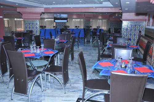 a dining room with tables and chairs with blue tablecloths at HOTEL DELTA ATLAS in Casablanca