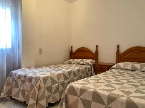 デニアにあるTalima Las Marinas 1-Servidenのベッドルーム1室(隣り合わせのベッド2台付)