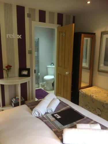 a bedroom with a bed and a bathroom with a toilet at Lowther House in Pickering