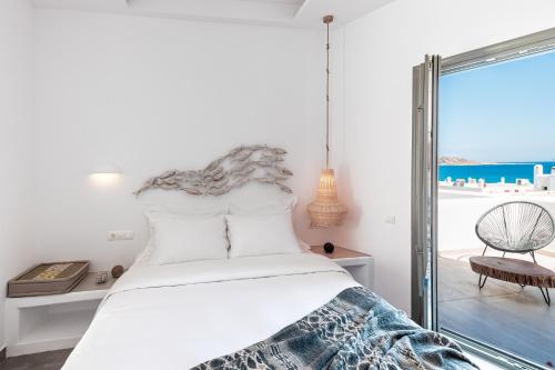 a bedroom with a bed with a view of the ocean at Bohemian Luxury Boutique Hotel, Adults Only in Naousa