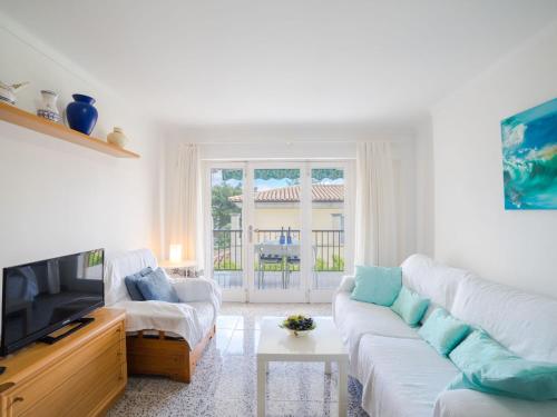 sala de estar con sofá blanco y TV en Apartment Los Girasoles by Interhome, en Alcudia
