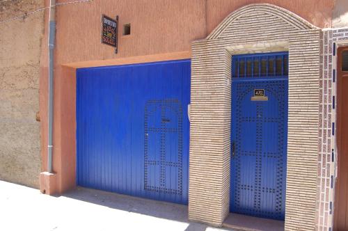 a blue garage with a door on the side of a building at Maison du Soleil in Tiznit