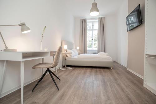 a white room with a desk and a couch at Boardinghouse Flensburg - by Zimmer FREI! Holidays in Flensburg