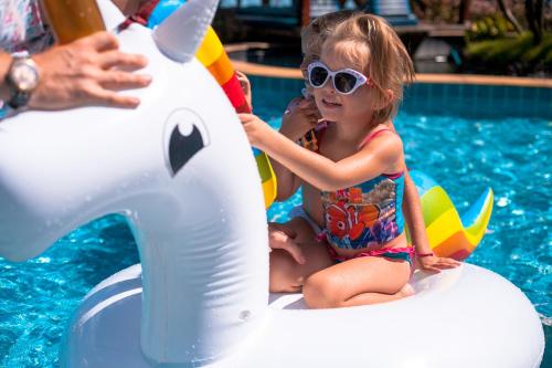 a little girl sitting on an elephant ride in a pool at Sea Valley Resort in Lipa Noi