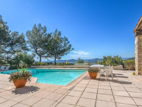 uma piscina com duas cadeiras e uma mesa em Villa Les Baux Rouges by Interhome em Solliès-Ville