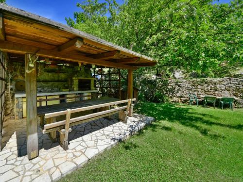 a wooden bench under a pavilion in a yard at Apartment Sandra by Interhome in Matulji