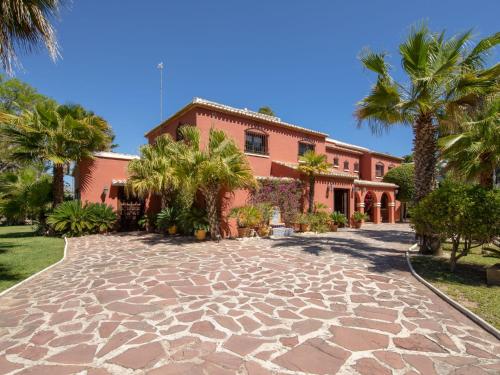 a house with palm trees and a stone driveway at Villa Villa Adelfa by Interhome in Jávea