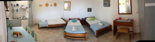 a kitchen with a table and chairs in a room at Villa Costa Studios in Vathi, Sifnos