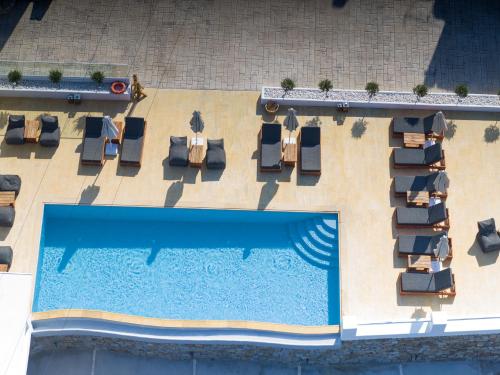 una vista aérea de una piscina con tumbonas y una piscina en Seethrough Mykonos Suites, en Platis Gialos