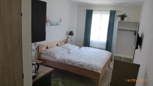 a small bedroom with a bed and a window at Penzion Sklář in Nový Bor