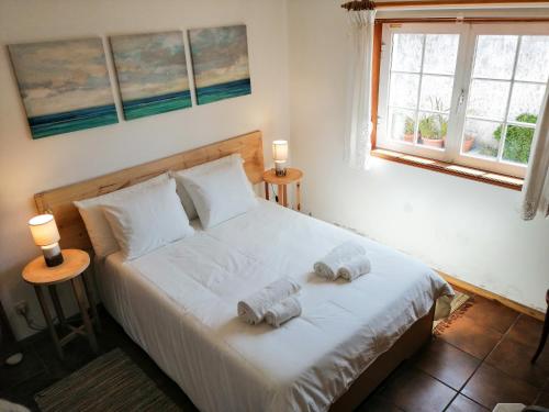a bedroom with a bed with towels on it at Casa da Balseira in Aveiro