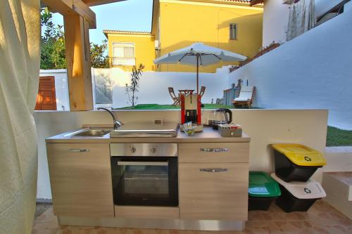 una piccola cucina con lavandino e ombrellone di B&B Sole E Luna a San Teodoro