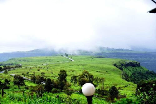 a view of a green field with a road at Vamoose Malvan Katta in Satara