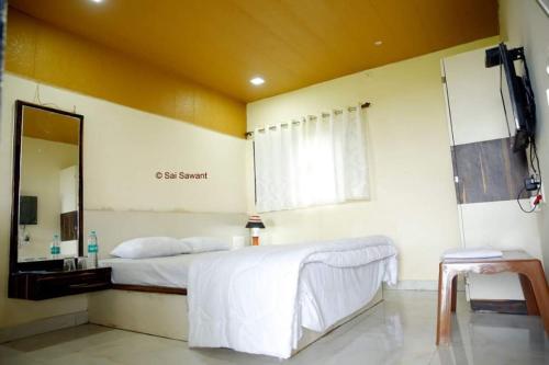 a bedroom with a large bed and a mirror at Vamoose Malvan Katta in Satara