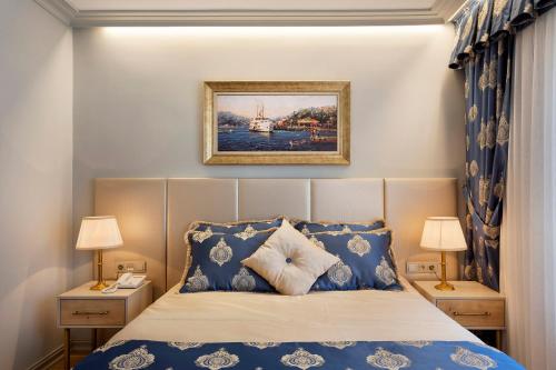 a bedroom with a bed with blue and white pillows at Güner Business Hotel in Istanbul