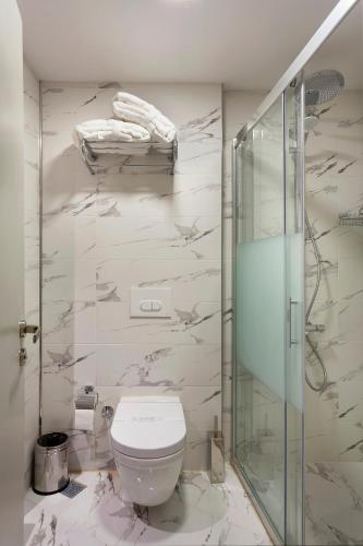a bathroom with a toilet and a glass shower at Güner Business Hotel in Istanbul