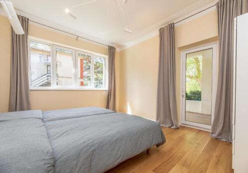 une chambre avec un lit et une grande fenêtre dans l'établissement Vila prie jūros, à Palanga