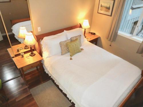 a bedroom with a large bed with two lamps on it at Belle Neige Whistler in Whistler