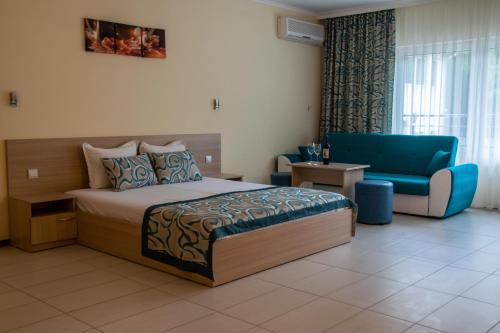 ein Hotelzimmer mit einem Bett und einem blauen Stuhl in der Unterkunft Park hotel Bellevue in Goldstrand