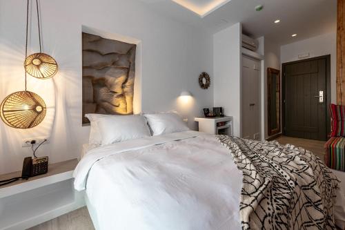 a white bedroom with a large white bed in it at Bohemian Luxury Boutique Hotel, Adults Only in Naousa