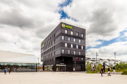 a large black building with a hotel sign on it at B&B HOTEL Cergy Saint Christophe in Cergy