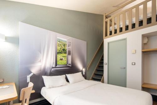 Un pequeño dormitorio con una cama y una escalera en B&B HOTEL Dieppe, en Saint-Aubin-sur-Scie