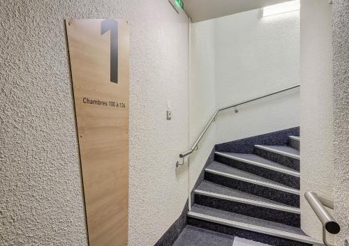 a stairway with a door with a sign that readsgraduate hotel at B&B HOTEL BEAUNE Nord in Savigny-lès-Beaune