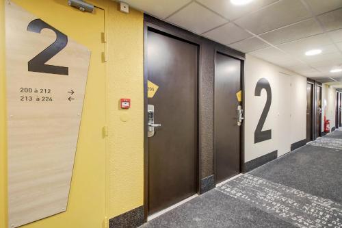 a row of elevators in a hallway with numbers on the wall at B&B HOTEL BEAUNE Nord in Savigny-lès-Beaune