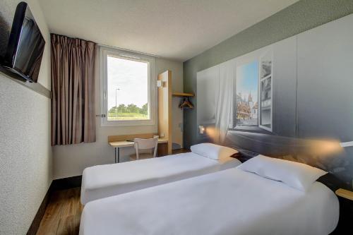 Postel nebo postele na pokoji v ubytování B&B HOTEL BEAUNE Nord