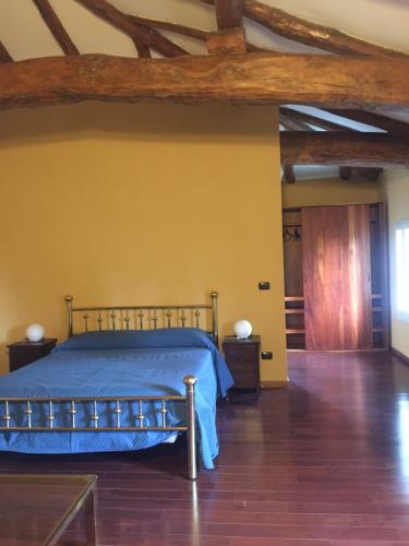 Schlafzimmer mit blauem Bett und Holzboden in der Unterkunft Villa Gioia in San Giorgio di Piano