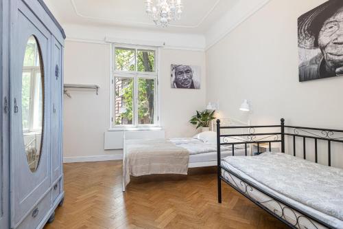 a bedroom with two beds and two windows at Modern History Apartment in Tallinn