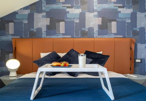 a bed with a table with a tray of food on it at Sealine Apartments A2 in Tivat