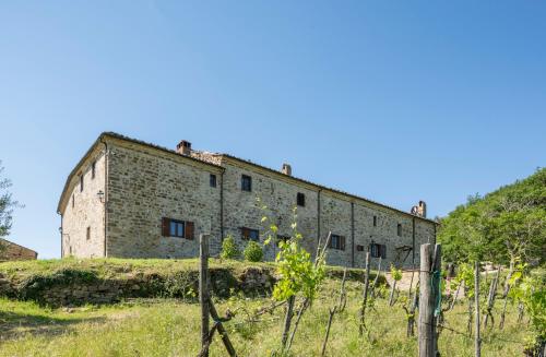 an old brick building on a hill with a fence at La Rimbecca Greve in Chianti in Greve in Chianti