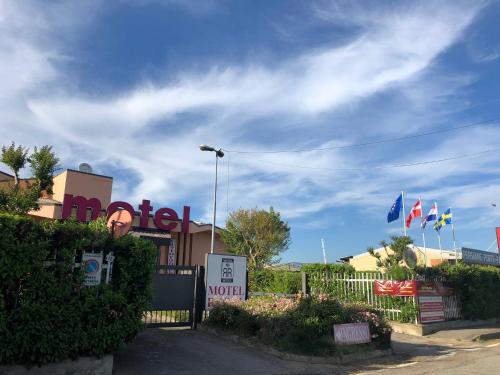 a fence in front of a building with flags at Hotel Motel Regal in Vermezzo