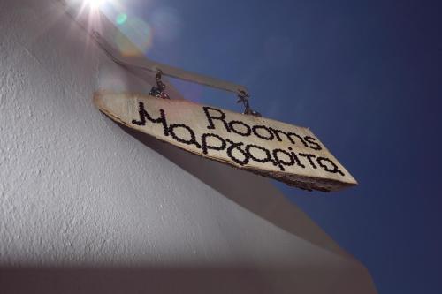 a sign hanging on the side of a wall at Margarita's Rooms in Chora Folegandros