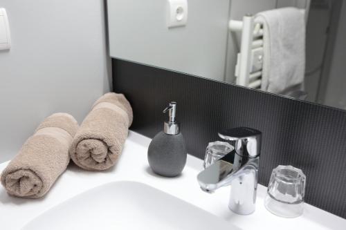 a bathroom with a sink with towels and a mirror at La Ferme du Bois Barbu in Villard-de-Lans