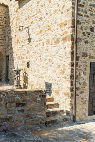 a building with a stone wall with a street light at La Rimbecca Greve in Chianti in Greve in Chianti
