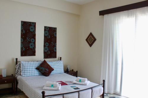a bedroom with a bed with a table and a window at Aumkara in Skala Eresou