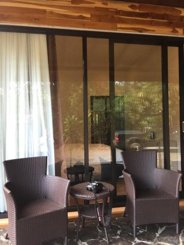 a screened in porch with two chairs and a table at Red island villas in Banyuwangi