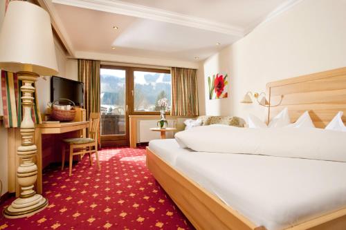 a hotel room with a bed and a television at Kirchenwirt in Reith im Alpbachtal