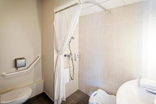 a bathroom with a shower and a toilet at B&B HOTEL Dieppe in Saint-Aubin-sur-Scie
