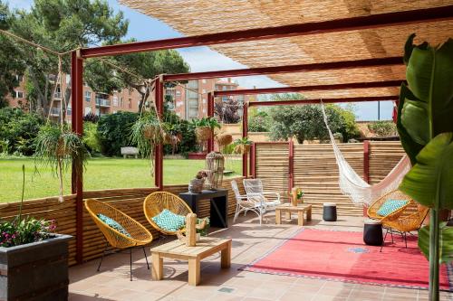 a patio with chairs and a hammock at Luna Park Hotel Yoga & Spa in Malgrat de Mar