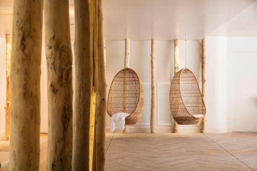 Luna Park Hotel Yoga & Spa في مالغرات دي مار: غرفة مع سلالتين الخوص على الحائط