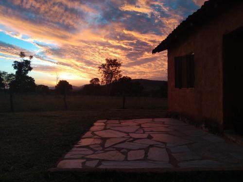 a sunset over a stone walkway next to a building at Recanto do Baru in Pirenópolis