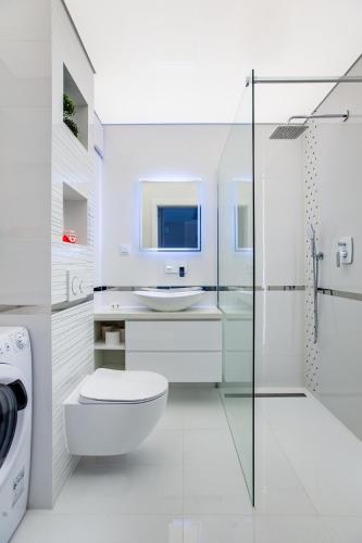 a white bathroom with a toilet and a sink at Apartamenty Bristol, Ul Piotra Ściegiennego 3 mieszkania 54 in Kielce